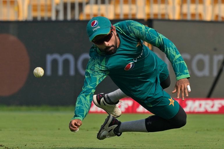 Pakistan's captain Babar Azam flies through the air to catch a ball