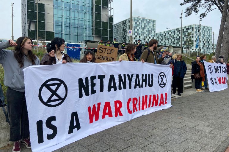 Activists hold up a banner denouncing Israeli Prime Minister Benjamin Netanyahu for Israel’s actions during the war with Hamas