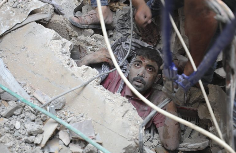 Palestinians rescue a survivor of Israeli bombardment of the Gaza Strip in Nusseirat refugee camp
