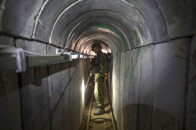FILE - An Israeli army officer gives journalists a tour of a tunnel allegedly used by Palestinian militants for cross-border attacks, at the Israel-Gaza Border July 25, 2014. An extensive labyrinth of tunnels built by Hamas stretches across the dense neighborhoods of the Gaza Strip, hiding militants, their missile arsenal and the over 200 hostages they now hold after an unprecedented Oct. 7, 2023, attack on Israel. (AP Photo/Jack Guez, Pool, File)