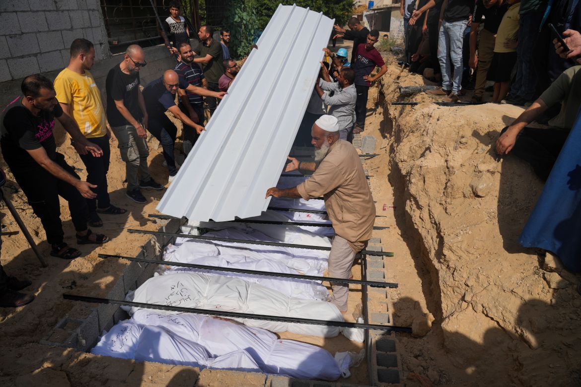 Palestinians bury the bodies of their relatives killed in the Israeli bombardment of the Gaza Strip, at a cemetery in Deir Al-Balah