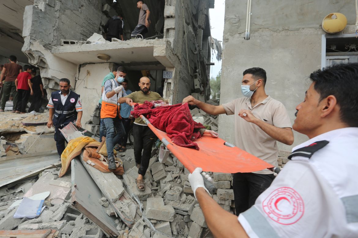 Palestinians evacuate a dead child from a building destroyed in the Israeli bombardment of the Gaza Strip in Rafah, Sunday