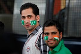Fans of Pakistan cricket team react to the camera as they wait to get inside the Chinnaswamy Stadium, the venue of first Twenty20 cricket match between India and Pakistan, in Bangalore, India, Tuesday, Dec. 25, 2012