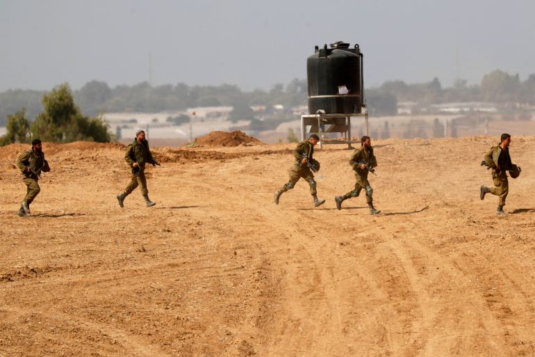 Israeli soldiers run to take position at an area along the border with Gaza, southern Israel