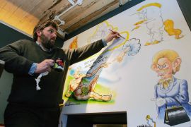 Cartoonist Steve Bell paints a mural at a new cartoon gallery in London, 22 February 2006