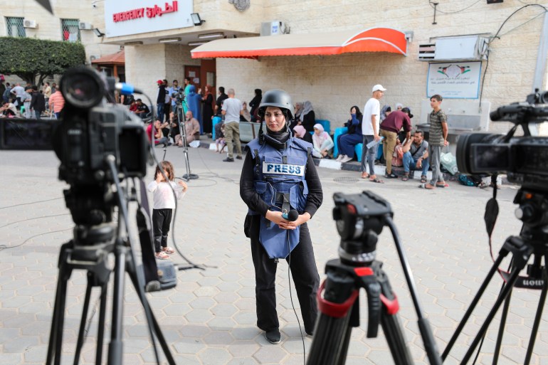 Khawla al-Khalidi, a journalist working for Palestine TV, Al-Hadath and Al Arabiya, stands in front of the camera for her first live at Al-Aqsa Martyrs Hospital in Deir al-Balah, central Gaza Strip