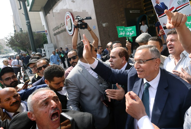 Head of Wafd Party Abdel-Sanad Yamama (R) waves to his supporters after submitting candidacy papers for the presidential election