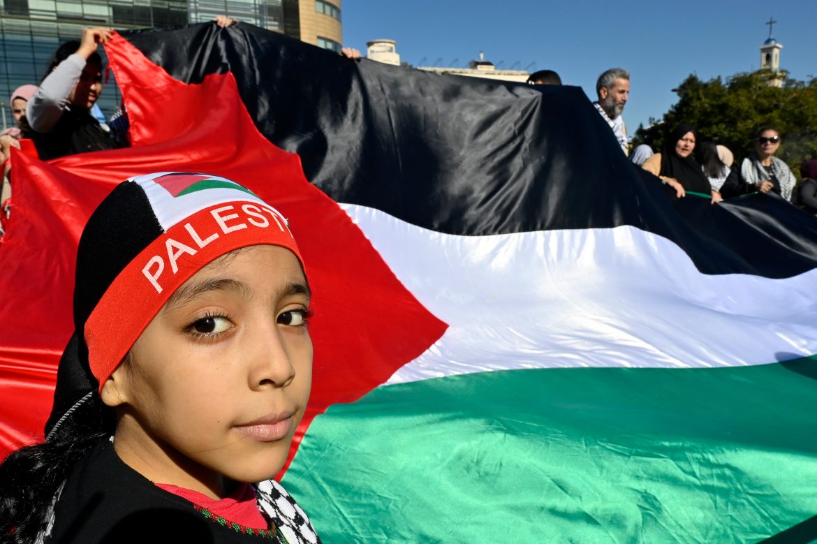 Palestinian and Lebanese activists carry a Palestinian flag during a protest in solidarity with the Palestinian people, under the slogan 'Stop the aggression and lift the siege on Gaza' outside of the United Nations Economic and Social Commission for Western Asia (UN-ESCWA) headquarters in Beirut, Lebanon.