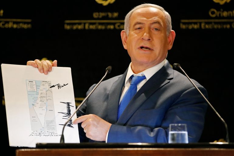 Israeli Prime Minister Benjamin Netanyahu displays a map of Israel indicating the Golan Heights are inside the state's borders, signed by US president Donald Trump and handed over to him by the president's son-in-law and adviser Jared Kushner during the same day, as he speaks in a hotel of Jerusalem on May 30, 2019.