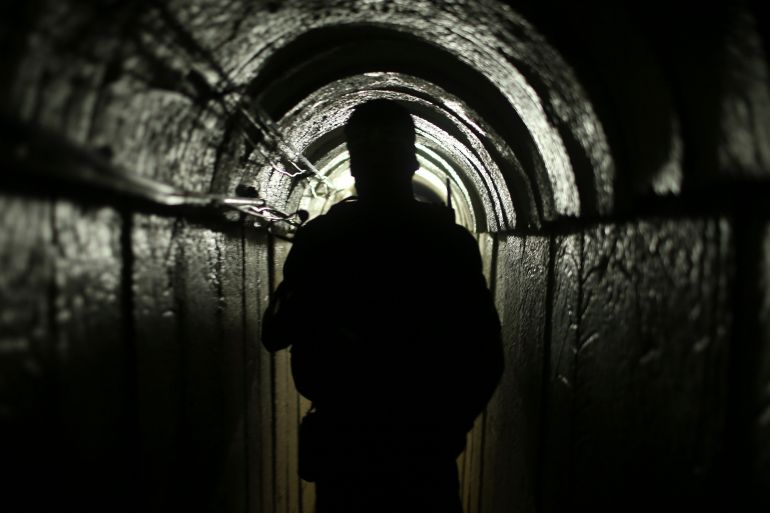 A Qassam fighter in silhouette in a tunnel