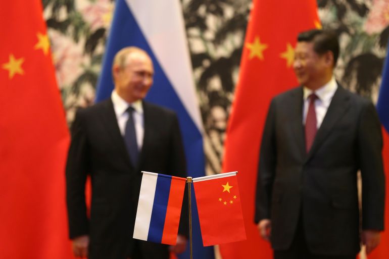 flags of China and Russia surrounding the countries' presidents