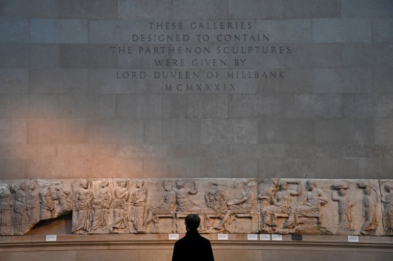 An employee poses as he views a relief which forms part of the Parthenon sculptures, sometimes referred to in the UK as the Elgin Marbles
