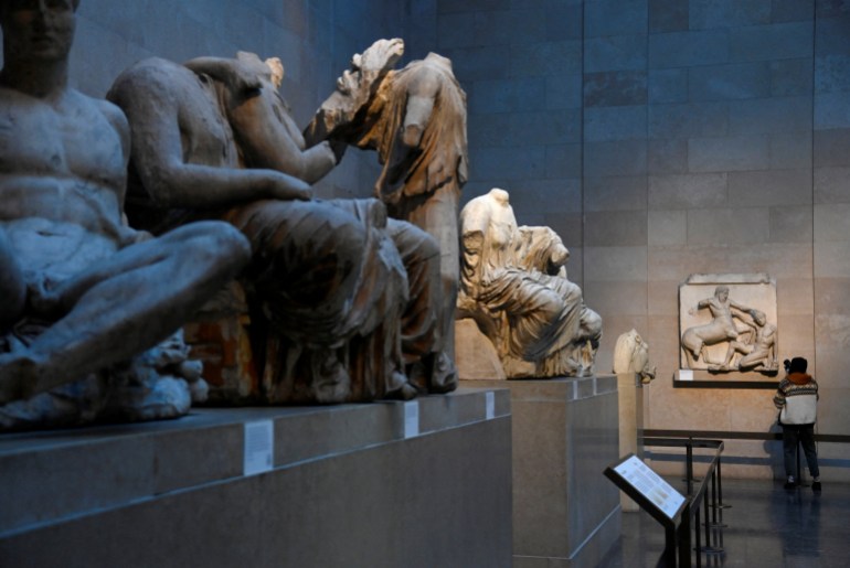 A media representative films sections of the Parthenon sculptures, sometimes referred to in the UK as the Elgin Marbles