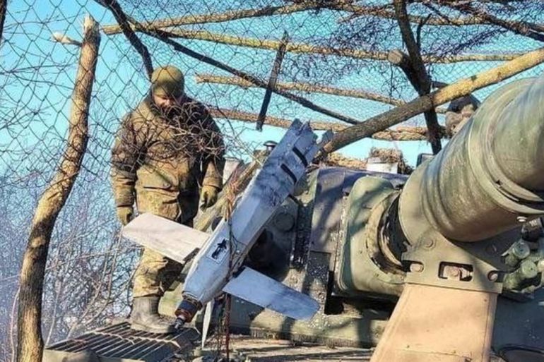 A suspected Russian Lancet drone on military equipment. A soldier is behind.