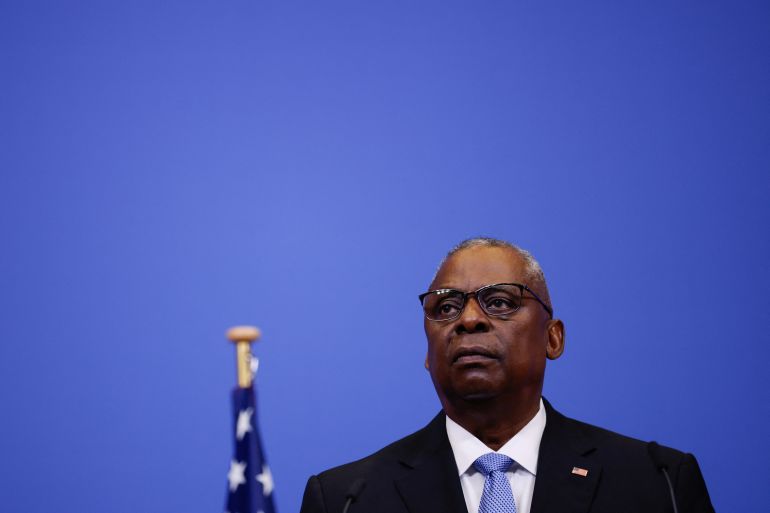 US Defense Secretary Lloyd Austin. He is pictured against a blue backdrop. The top of the US flag can be seen behind him