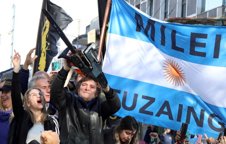 calon presiden Argentina Javier Milei memegang gergaji mesin di samping Carolina Piparo, calon Gubernur Provinsi Buenos Aires