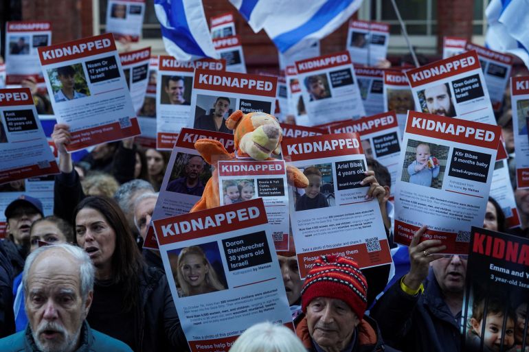 Demonstrators in London hold banners as they form a human chain outside the Qatar embassy in a protest calling for the release of the Israeli hostages.