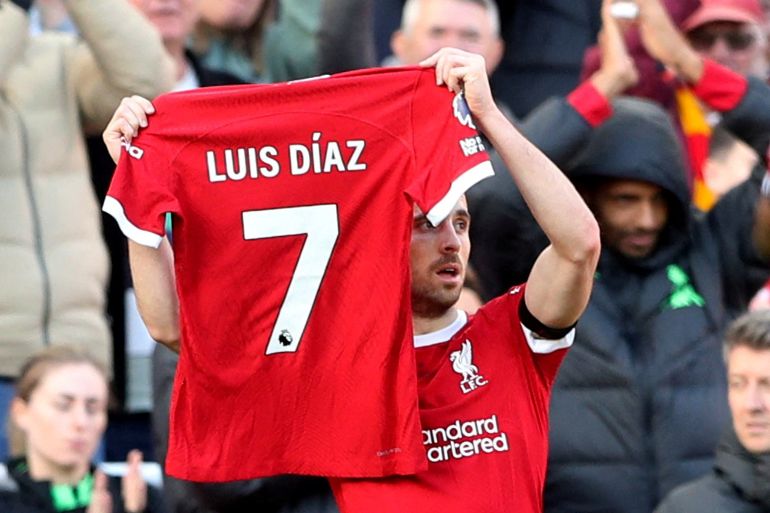 Liverpool's Diogo Jota holds up a shirt in support of Liverpool's Luis Diaz