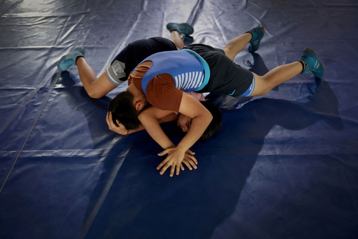Students wrestle during a bout, in the training room at the Altius wrestling school in Sisai, Haryana, India.