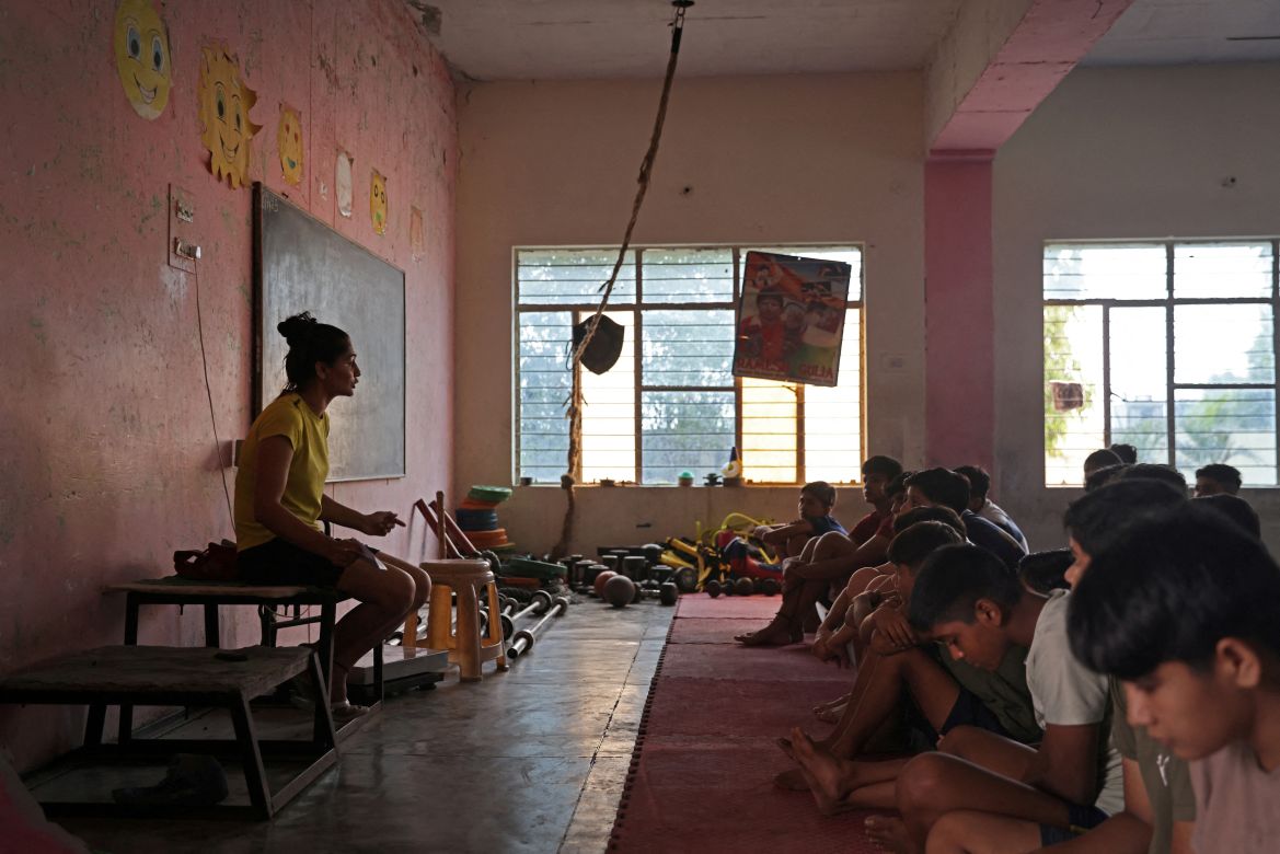 Wrestling coach Naveen Sihag, 28, speaks to the students in the training room during rest day, at The Altius Wrestling School in Sisai, Haryana, India.