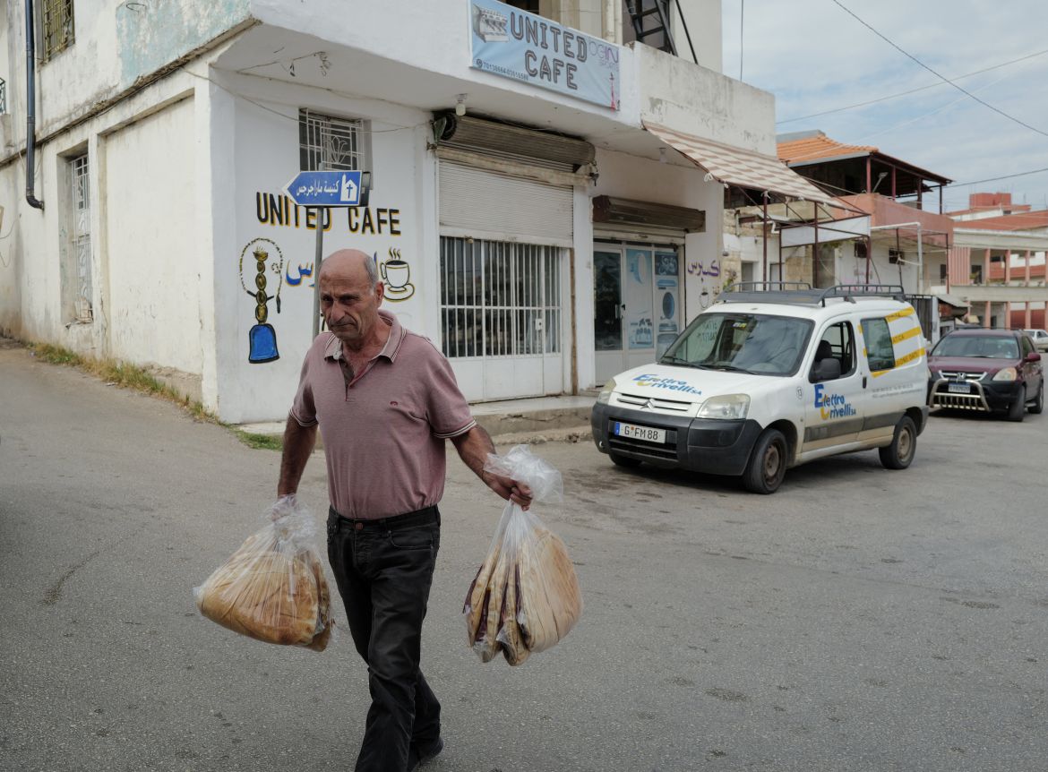 A man carries bags of bread to sell, amidst tension between Israel and Hezbollah, in the Christian village of Rmeish, Lebanon.