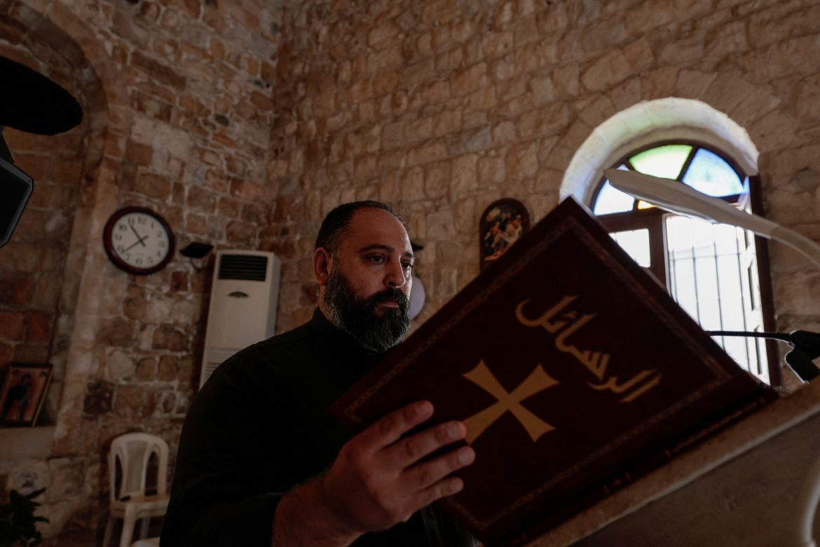 Toni Elias 40, the priest of the Christian village of Rmeish reads, amidst tension between Israel and Hezbollah, at Saint George church in the Southern village of Rmeish, Lebanon.