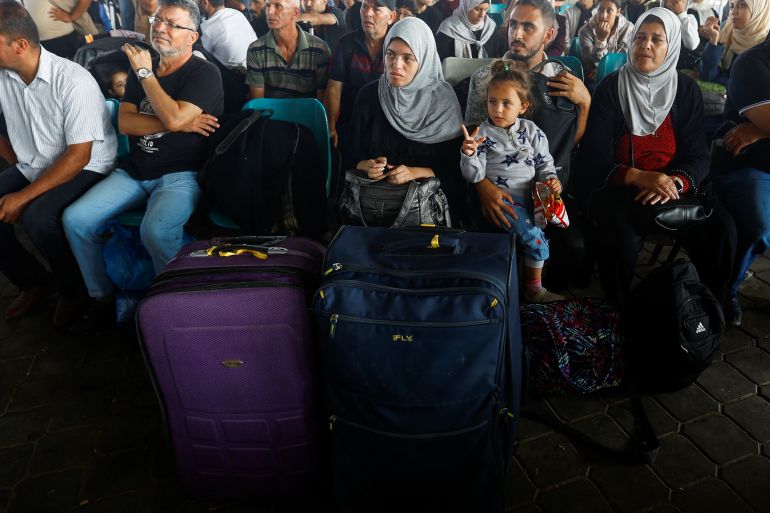 Palestinians with dual citizenship wait for permission to leave Gaza, amid the ongoing conflict between Israel and Palestinian Islamist group Hamas, at the Rafah border crossing with Egypt,
