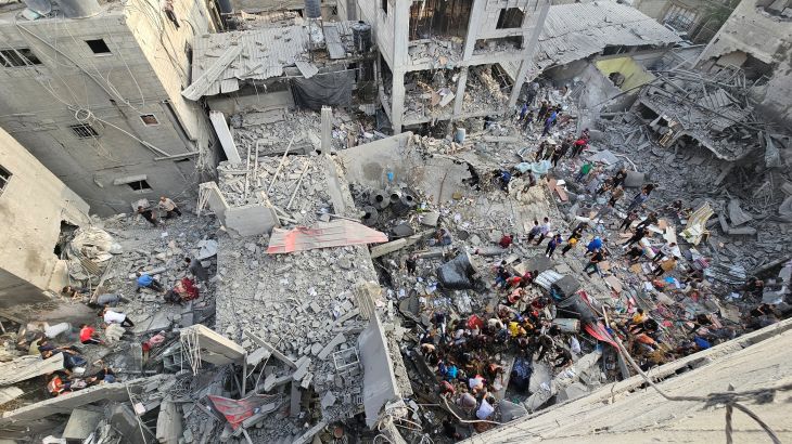 Palestinians search for casualties at the site of Israeli strikes on houses, in Jabalia refugee camp