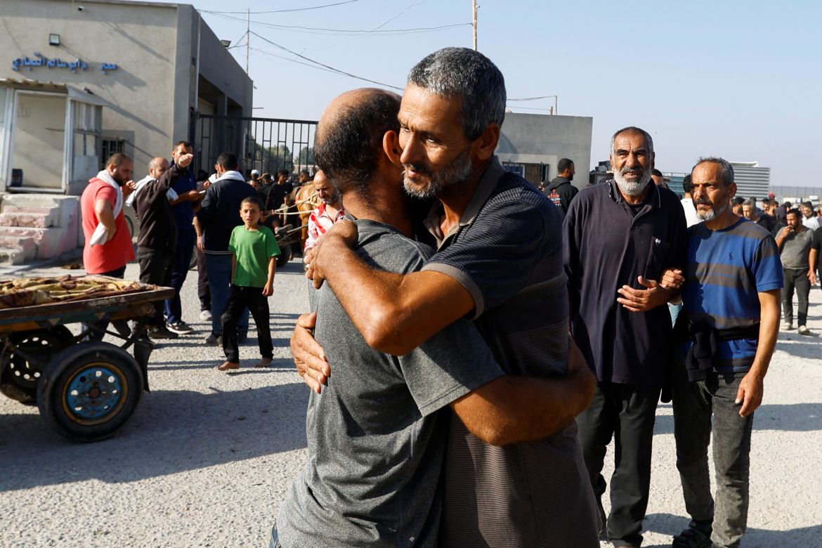 Palestinian labourers, who were in Israel during the Hamas October 7 attack, embrace as they arrive at the Rafah border after being sent back by Israel to the strip, in the southern Gaza Strip.