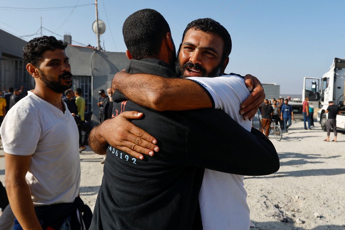 A Palestinian labourer, who was in Israel during the Hamas October 7 attack, is greeted as he arrives at the Rafah border after being sent back by Israel to the strip, in the southern Gaza Strip.