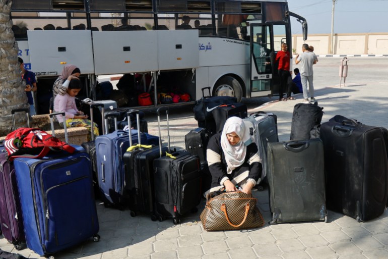 Una mujer palestina con pasaporte extranjero mira su bolso mientras espera permiso para salir de Gaza, en medio del conflicto en curso entre Israel y el grupo islamista palestino Hamás en la frontera de Rafah.