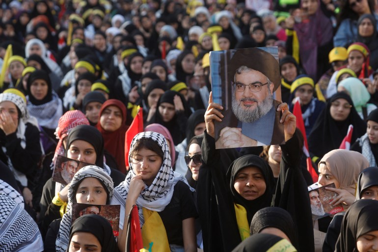 Una donna tiene in mano una foto del leader libanese di Hezbollah Sayyed Hassan Nasrallah 