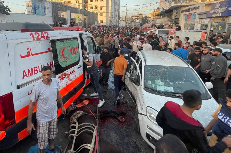 Palestinesi accertano i danni dopo l'impatto con un convoglio di ambulanze all'ingresso dell'ospedale Shifa di Gaza City