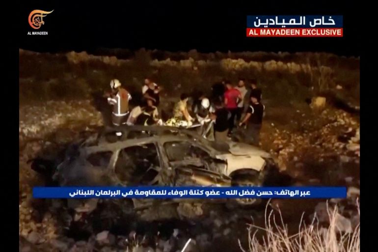 Footage from Al-Mayadeen Tv shows emergency teams working next to a burnt vehicle at the scene where Hezbollah says an Israeli strike killed three children, in southern Lebanon, November 5, 2023.
