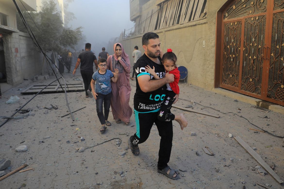 Palestinians evacuate the site of Israeli strikes on houses, amid the ongoing conflict between Israel and Palestinian Islamist group Hamas, in Maghazi refugee camp in the central Gaza Strip