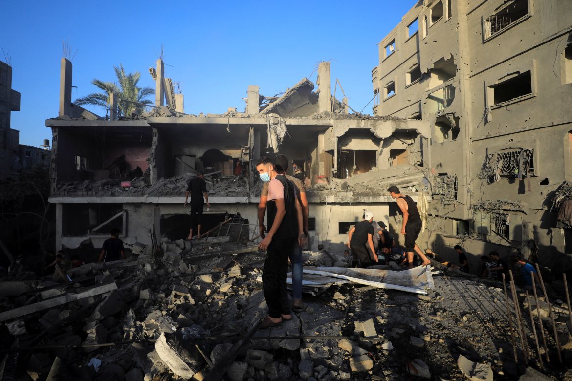 Palestinians search for casualties at the site of Israeli strikes on houses, amid the ongoing conflict between Israel and Palestinian Islamist group Hamas, in Maghazi refugee camp in the central Gaza Strip, November 6