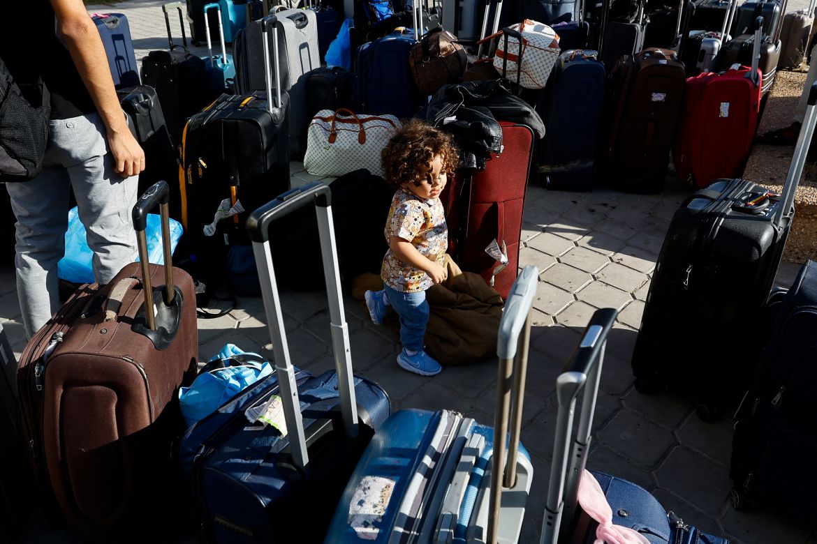 A child walks between luggages as Palestinians with foreign passports wait for permission to leave Gaza, amid the ongoing conflict between Israel and Palestinian Islamist group Hamas, at the Rafah border crossing with Egypt