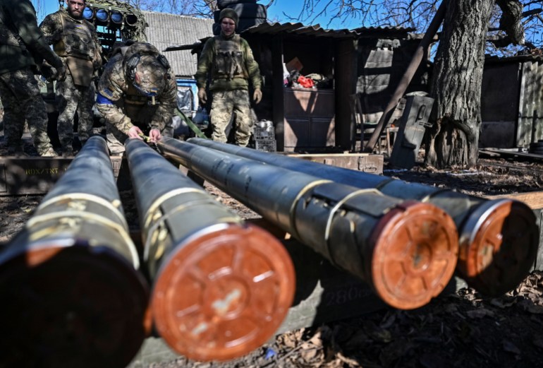 Ukrainian soldiers prepare grenades in the southern Zaporizhia region.  The shells are lined up in the front of the photo.