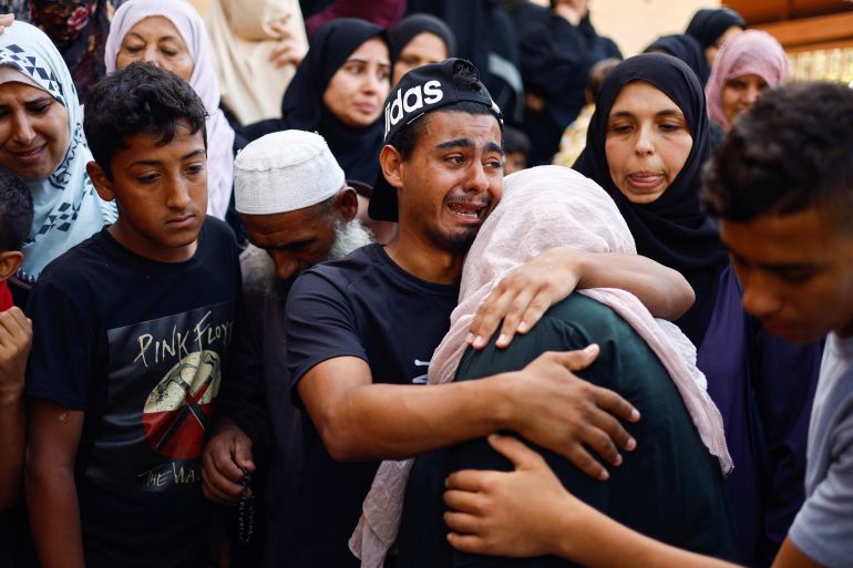 People mourn Palestinians killed in Israeli strikes, amid the ongoing conflict between Israel and Palestinian Islamist group Hamas, at a hospital in Khan Younis