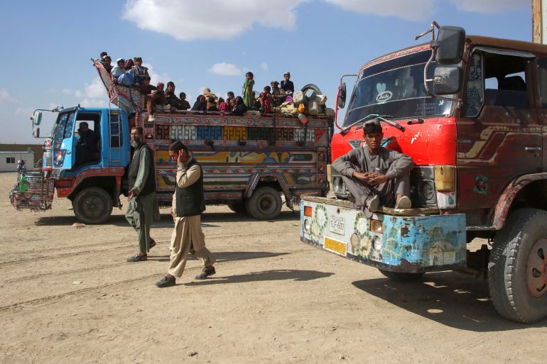Afghan men walk as a family boards a truck as they head back to Afghanistan from Pakistan, at the Chaman Border Crossing along the Pakistan-Afghanistan Border in Balochistan Province, in Chaman, Pakistan November 9, 2023