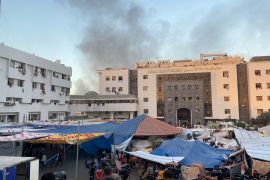 Smoke rises as displaced Palestinians take shelter at Al Shifa hospital