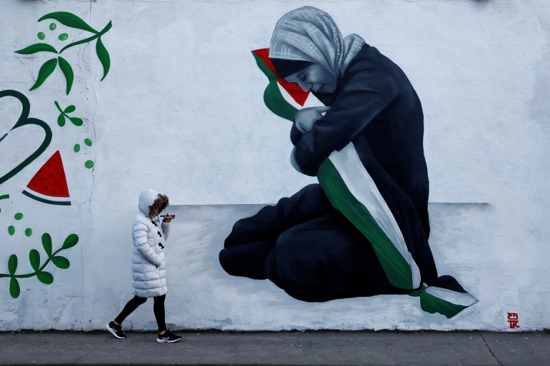 A woman walks past a mural by Emmalene Blake in solidarity with Palestinians in Gaza, amid the ongoing conflict between Israel and the Palestinian Islamist group Hamas, in Dublin, Ireland, November 15, 2023. REUTERS/Clodagh Kilcoyne