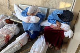 Palestinian women mourn as they hold the bodies of children killed in Israeli strikes, amid the ongoing conflict between Israel and Hamas, at the Indonesian hospital, in the northern Gaza Strip November 18
