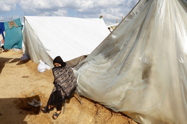A displaced Palestinian sits by a tent, amid the ongoing conflict between Israel and Palestinian Islamist group Hamas, in a tent camp in Khan Younis in the southern Gaza Strip, November 20, 2023. REUTERS/Ibraheem Abu Mustafa
