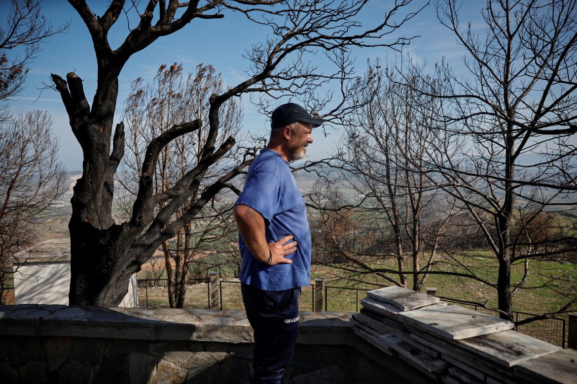 Vasilis Tsiamitas, 46, looks over at his village from the burned-out Saint John's church in the village of Sesklo, Greece.