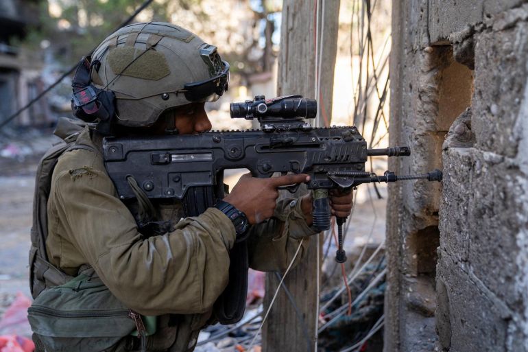 An Israeli soldier takes position in Gaza