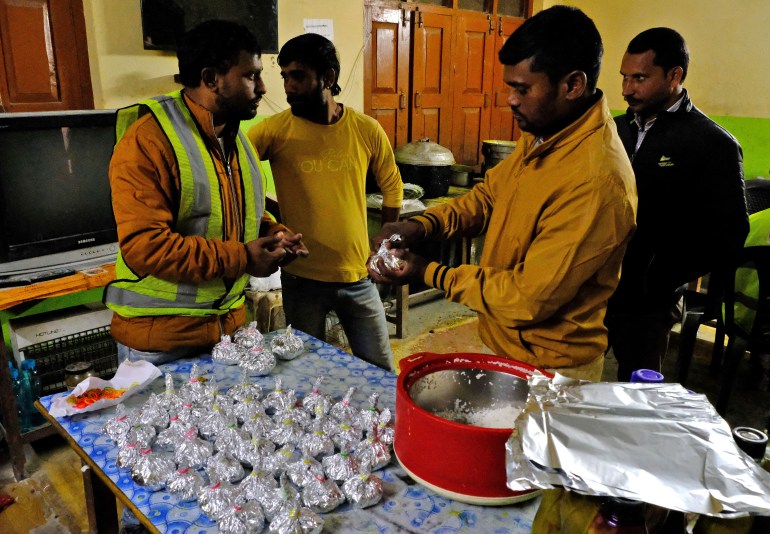 Rescue workers pack rice to be sent to workers who have been trapped for ten days inside a collapsed tunnel in Uttarkashi in the northern state of Uttarakhand, India, 