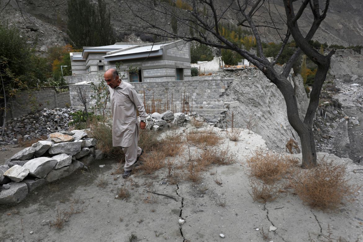 Community leader Sultan Ali, 70, walks over cracks that developed after a Glacial Lake Outburst Flooding (GLOF) swept away part of the land in Hassanabad village, Hunza valley, in the Karakoram mountain range in the Gilgit-Baltistan region of Pakistan.