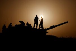 Israeli soldiers stand on a tank, amid the ongoing conflict between Israel and the Palestinian group Hamas, near Israel's border with Gaza in southern Israel, November 23, 2023. REUTERS/Amir Cohen TPX IMAGES OF THE DAY