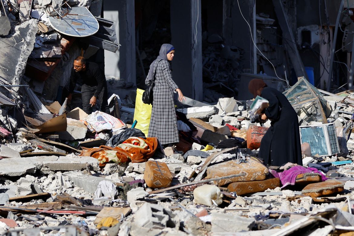 Palestinians stand among the rubble of a house destroyed in an Israeli strike during the conflict, amid the temporary truce between Hamas and Israel, in Khan Younis in the southern Gaza Strip November 24